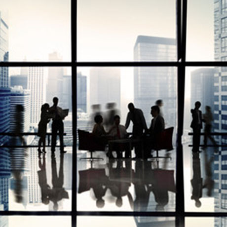 Planta de un edificio de cristaleras con gente en sombra dialogando.
