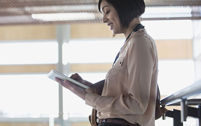 Chica morena con una tablet en la mano.